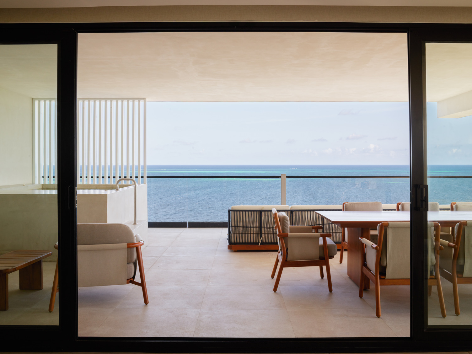 Open-air terrace of AVA 5-Bedroom Panoramic Villa 2 with ocean view, modern seating, and glass balcony railing.