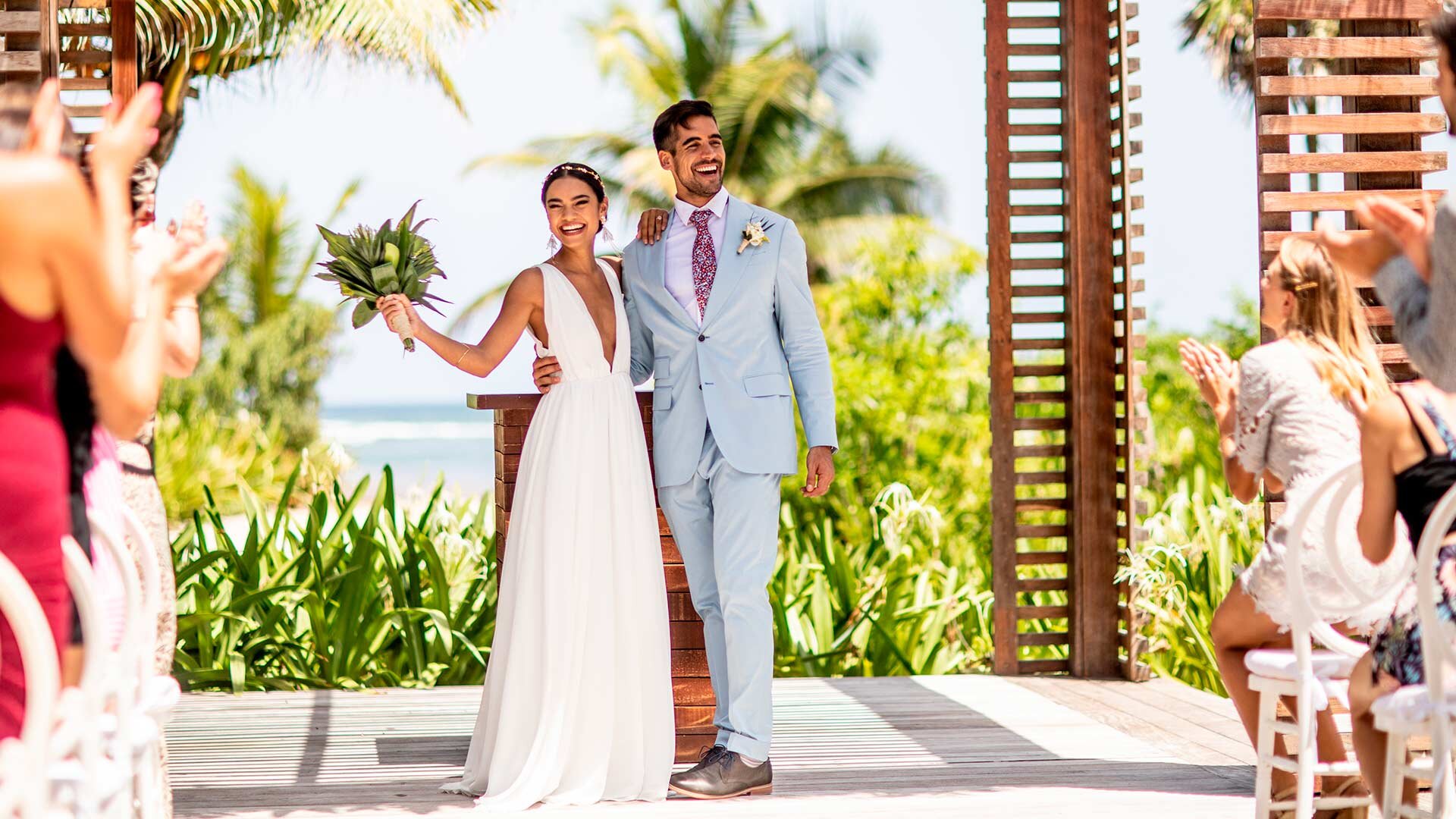 Wedding ceremony at UNICO 20°105° with a couple standing beneath a tropical altar