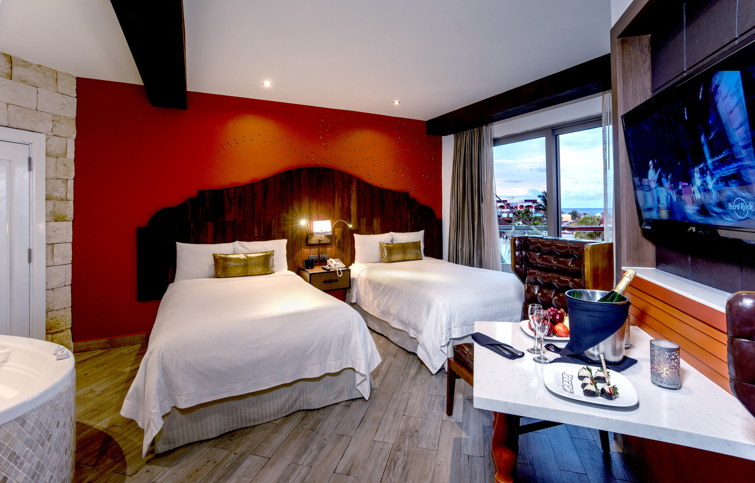 Habitación de hotel con dos camas dobles, vista al mar, balcón, televisor de pantalla plana y un jacuzzi en el Hard Rock Rivi